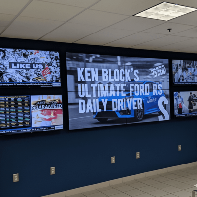 Dealership sales video wall showcasing performance leaderboards, promotions, and team recognition in real time.